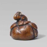 A boxwood netsuke of a young rat. Mid-19th centurySitting on top of a large bag, possibly