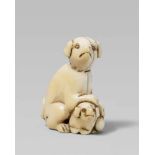 An ivory netsuke of two dogs. Early 19th centurySeated on its hind legs, the larger animal