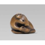 An Ise school boxwood netsuke of a rat with a fruit. Second half 19th centurySitting with tail