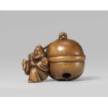 A boxwood netsuke of a laughing shrine attendant with a huge bell. Early 19th centuryWearing an