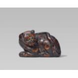 An unusual umimatsu netsuke of a tiger. 19th centuryReclining cat-like with forepaws placed close