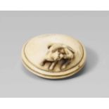 An ivory netsuke of a small skinny dog. 19th centuryReclining on a large round cushion with a