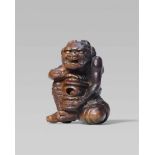 A rare and interesting wood netsuke of an oni with a reliquary, by Awataguchi. First half 19th