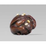 An amusing wood netsuke of an oni at setsubun, by Ikka? First half 19th centuryA muscular oni