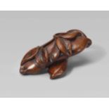 A wood netsuke of two bean pods. 19th centuryPlaced across each other, with two leafy twigs lying on