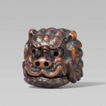 A large Tomotada-type boxwood netsuke of a shishimai mask. Early 19th centuryThe square-shaped