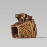 An Ise school boxwood netsuke of a toad on a bucket, by Masanao. Mid-19th centurySitting with head