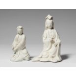 Zwei blanc de Chine-Figuren einer GuanyinSitzende Guanyin, ganz bedeckt mit einer cremeweißen