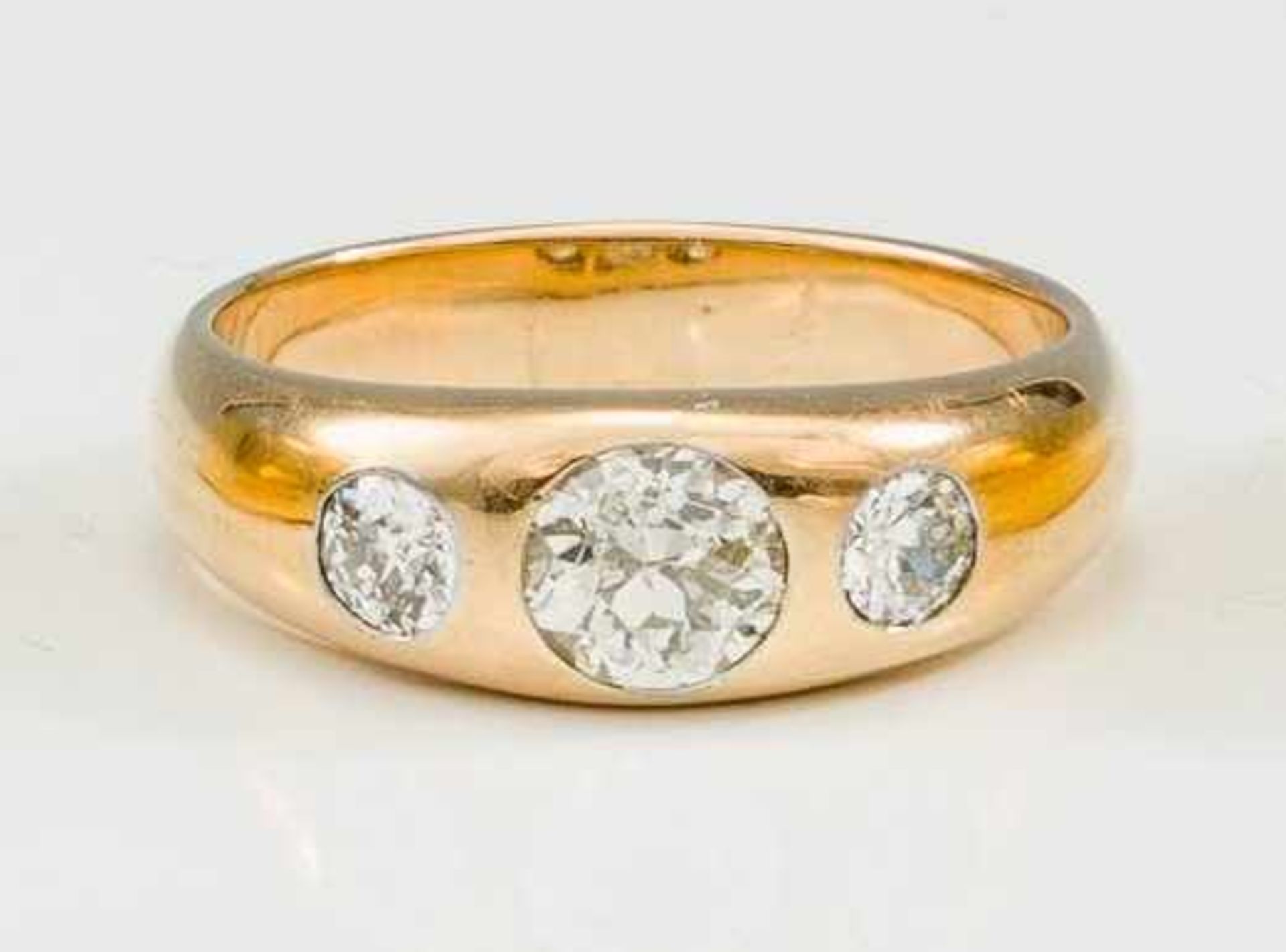 Goldbandring. 585/f. Gold. Ausgefasst mit Brillant von ca. 1,00 ct., flankiert von 2 Brillanten