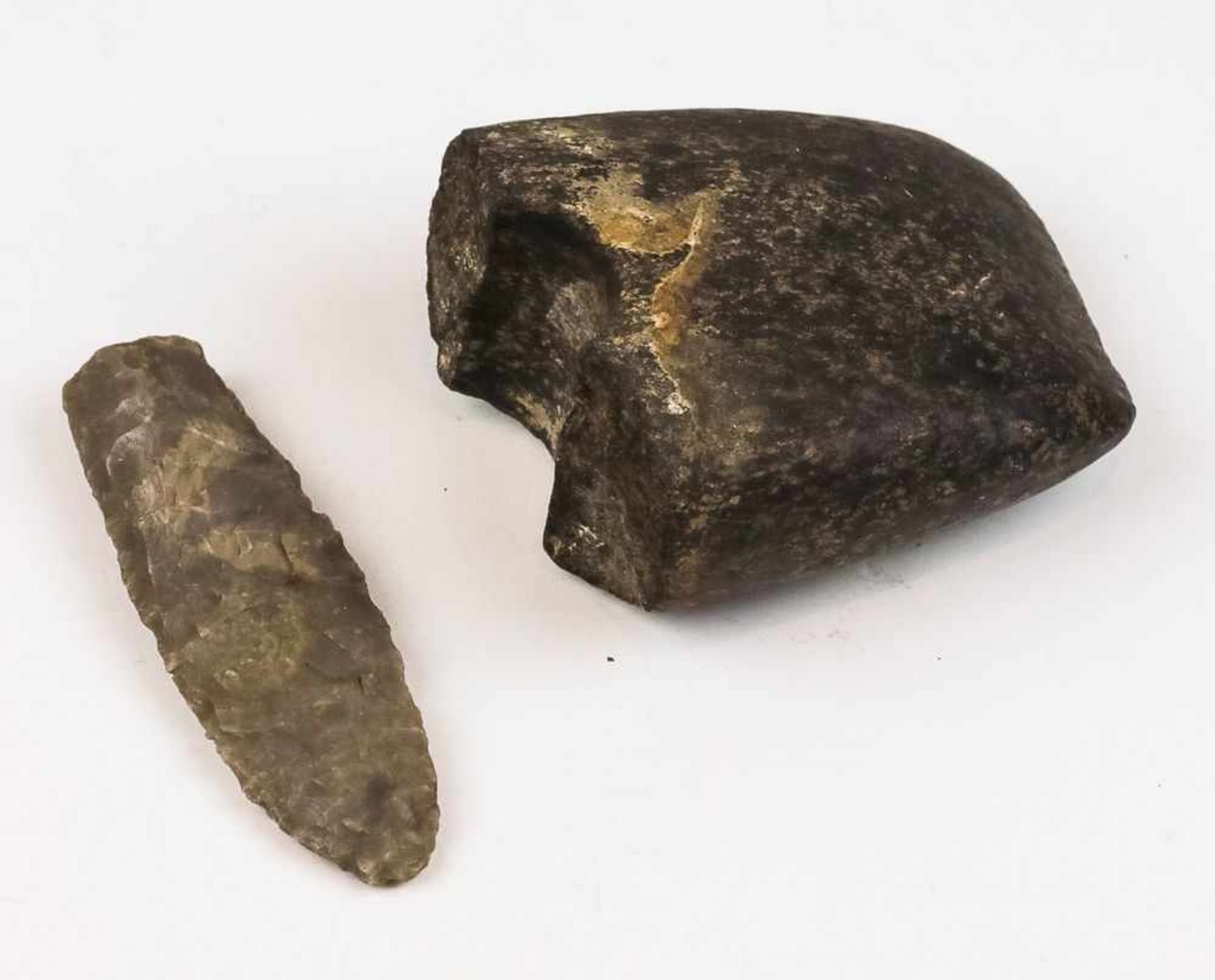 Neolithische Speerspitze. Feuerstein. Gr. ca. 10×3 cm. Und: Fragment einer neolithischen Dechsel. An