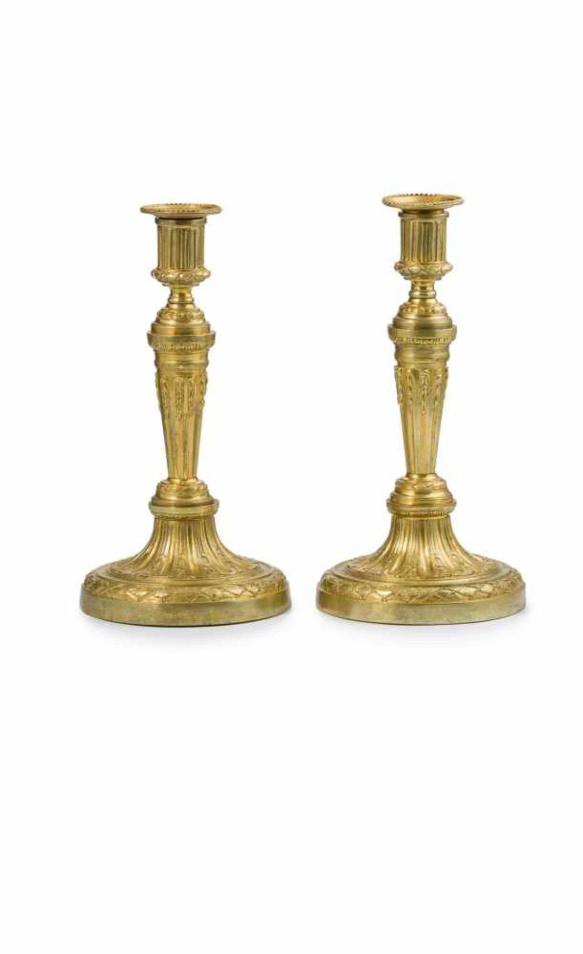 Ein Paar Leuchter, Louis XVI Bronze, vergoldet. Kannelierter Säulenschaft und Rundfuß. Um den Fuß