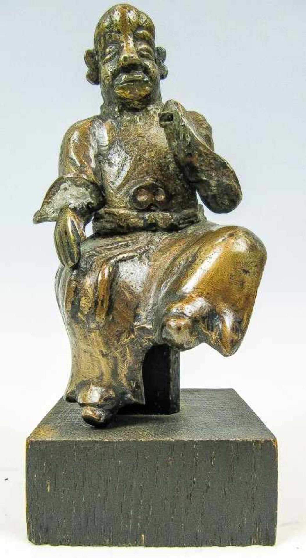 Kl. Figur eines sitzenden Mönches.Bronze, patiniert. H. 14,5 cm. (Rep., besch.). Holzsockel.(55301)