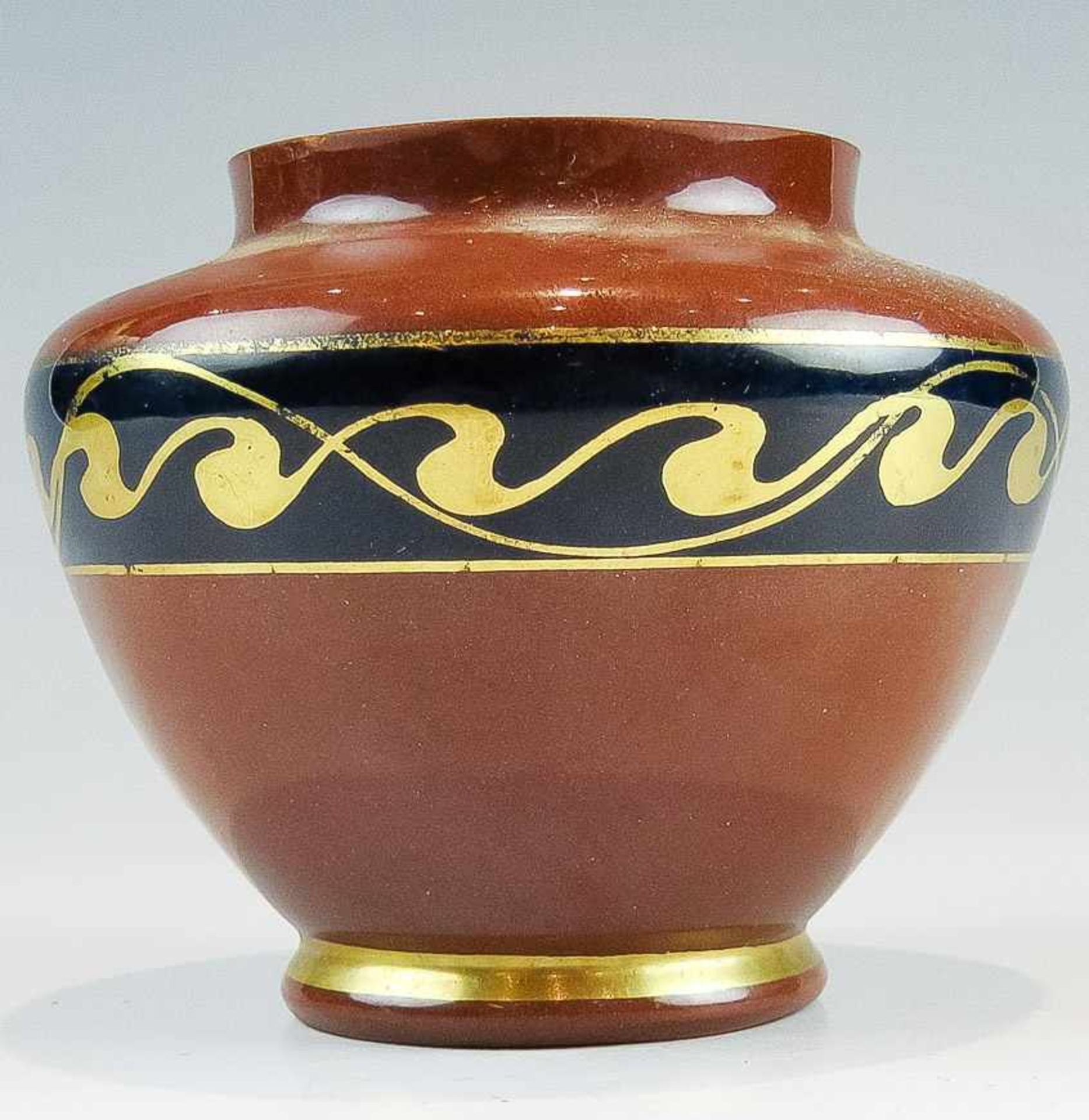 Kl. Vase. Cadinen.Keramik. Ziegelrot mit goldener Laufender-Hund-Bordüre auf kobaltblauem Grund.