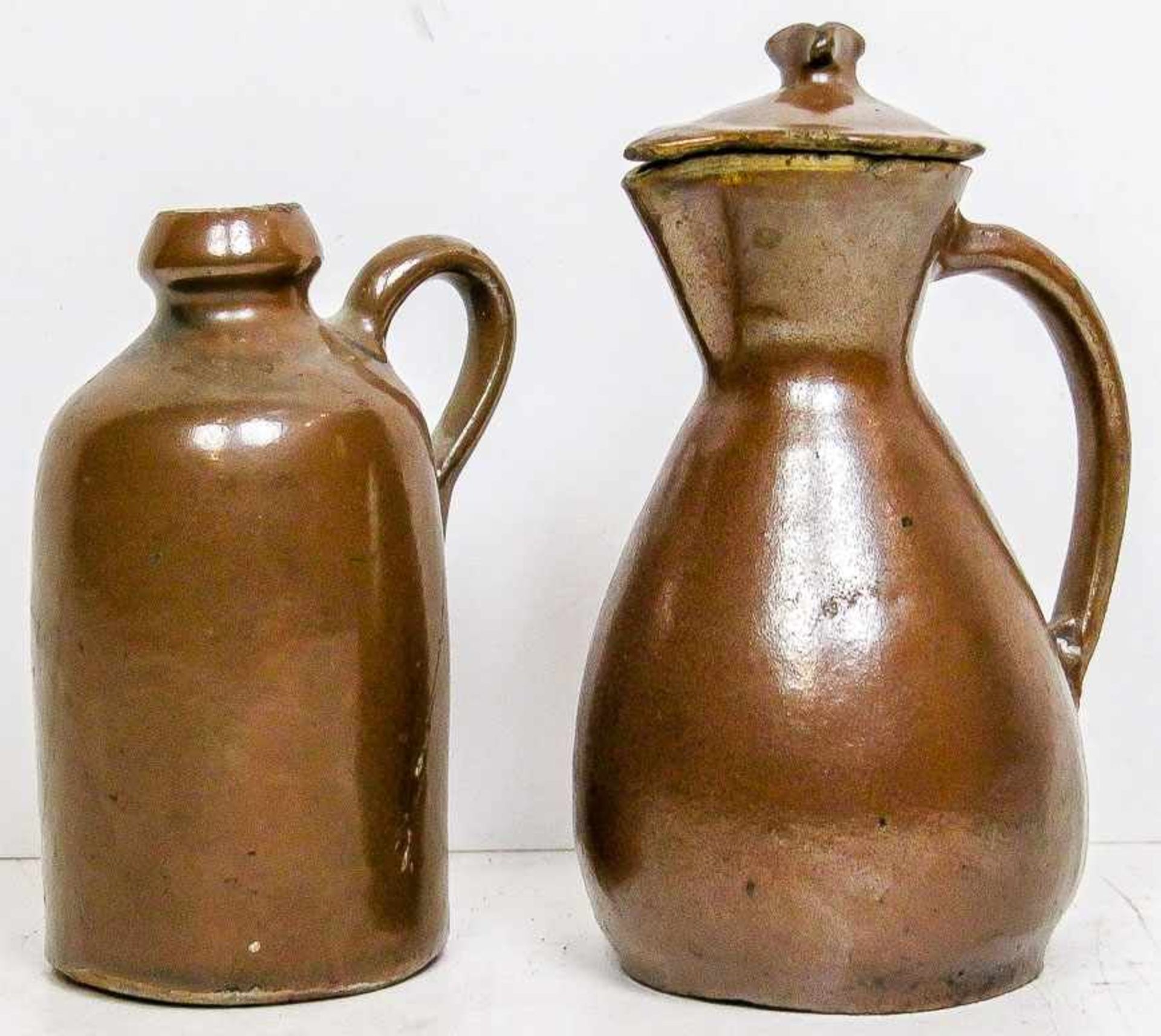 Kl. Kanne und Deckelkännchen.Bunzlau, 19. Jh.Steinzeug. Braune Lehmglasur. H. 12,5 bzw. 15 cm. (