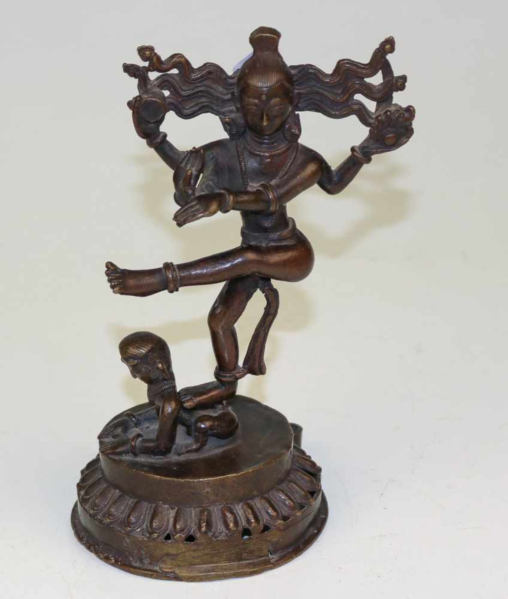 Shiva über einem knienden Menschen tanzendTibetZweiteilige Bronze, dunkel patiniert. Lotossockel. H.