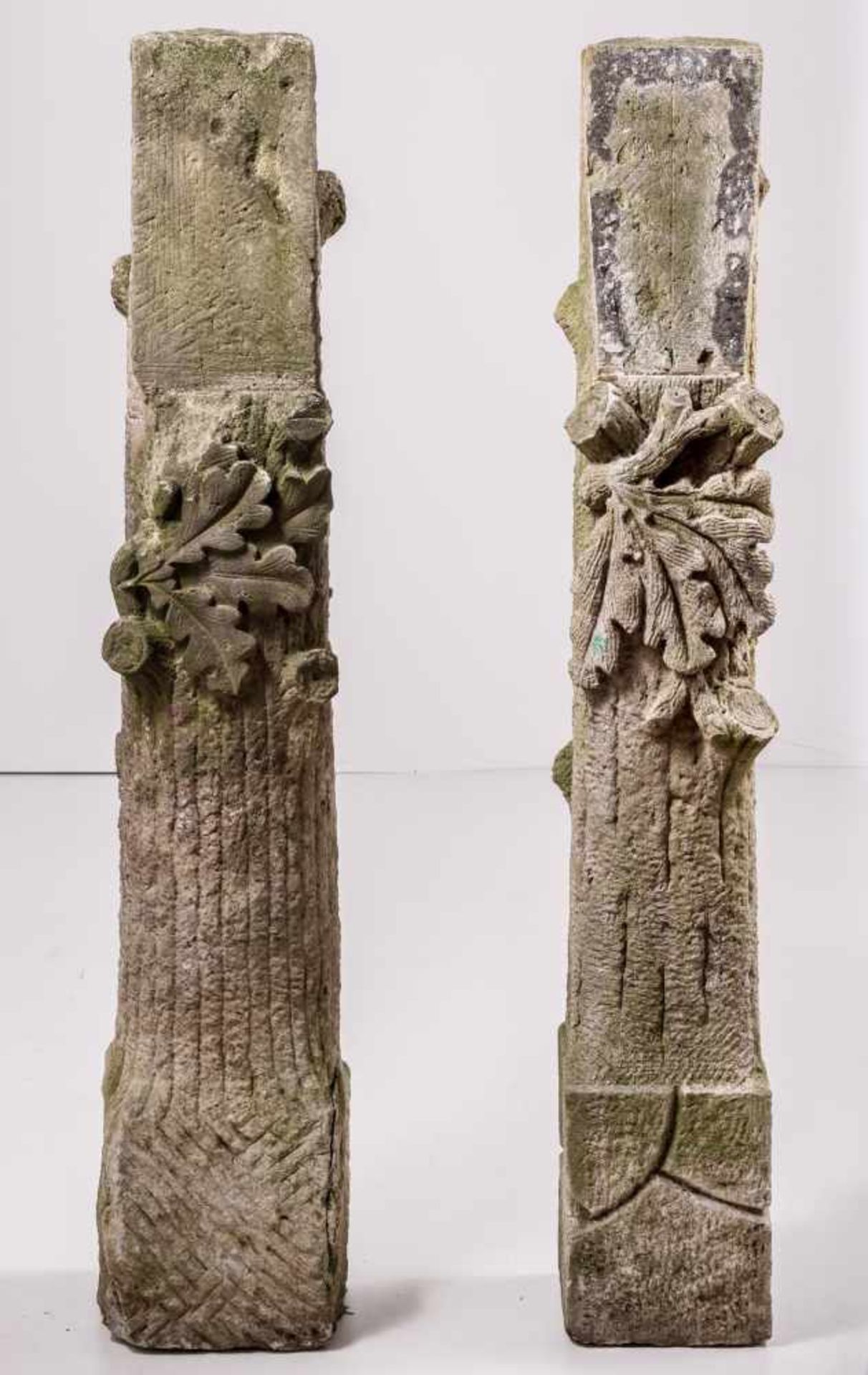 Zwei Sandsteinstelen als Baumstümpfe mit AstansätzenVorstehendes Eichenlaub und abgeschrägtes