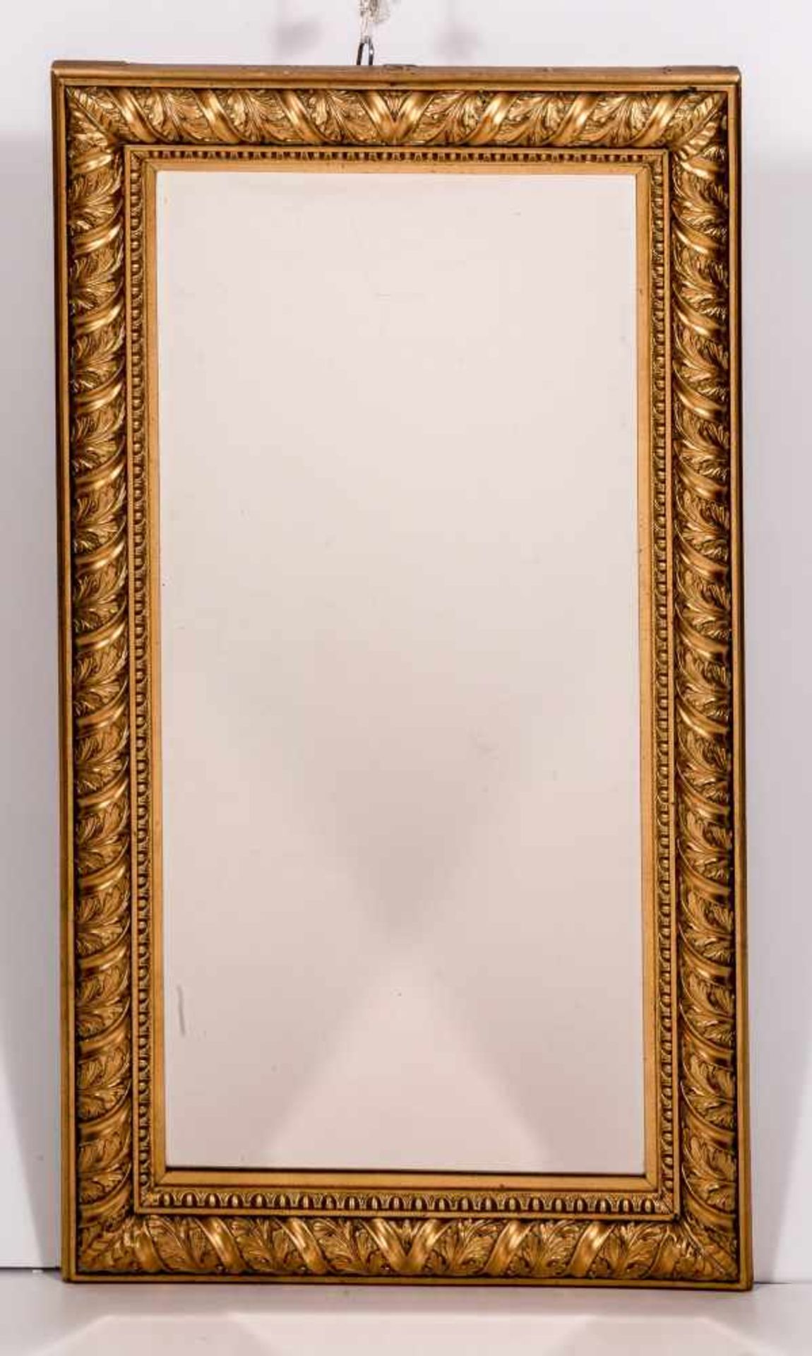 Rahmenspiegel mit klassizistischem DekorHolz mit Stuckauflage, vergoldet. Gerundete Leiste mit