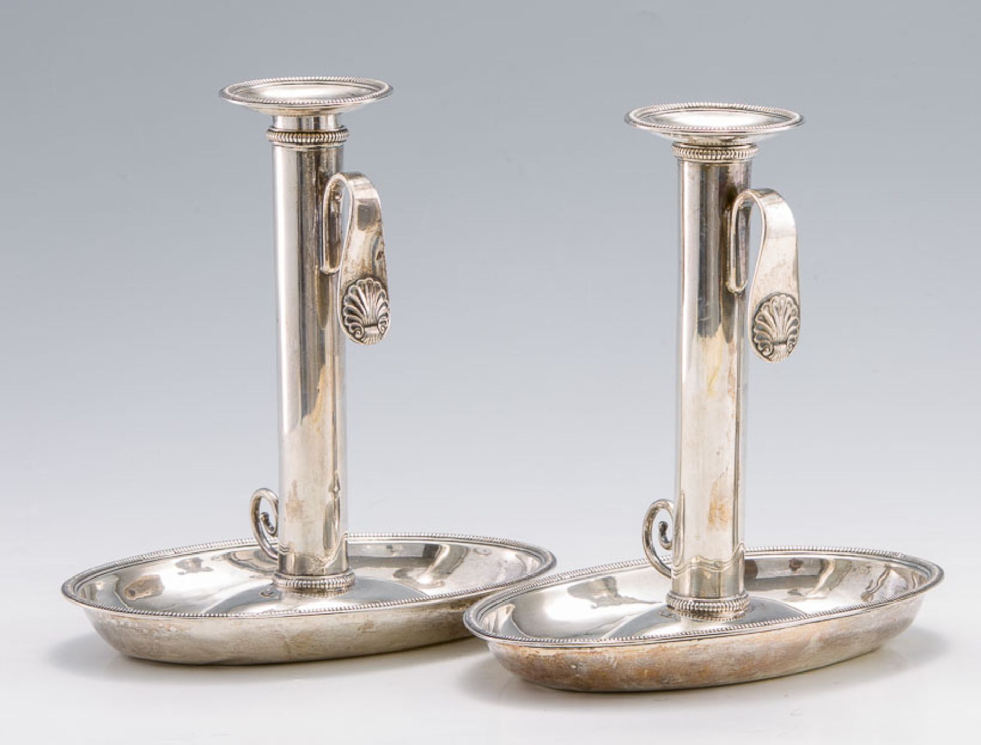 Ein Paar TrageleuchterWohl PortugalMit ovalem Tellerfuß. Perlfriesdekor. H. 22 cm. Gew. zus. ca. 900