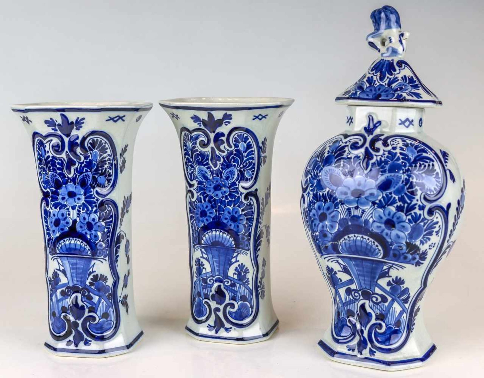 Dreiteiliger VasensatzDelftFayence. Weiße Glasur, Blaumalerei. Zwei Flötenvasen, Balusterdeckelvase.