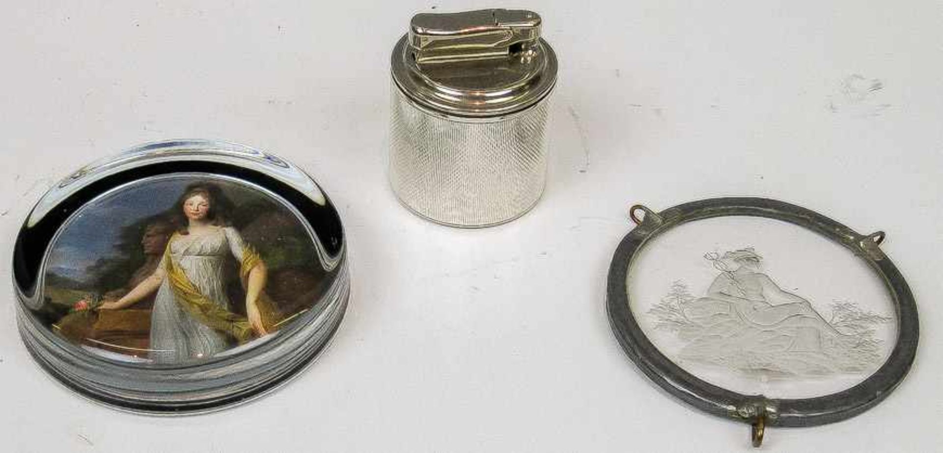 Gas-Tischfeuerzeug Mit guillochierter Silberummantelung. H. 6 cm. Beigegeben: Kl. runder