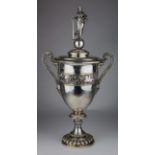 Large silver twin handled trophy, ornately decorated with Roman figures, chariots and horses, lid