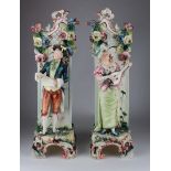 Two large ornate Continental flower vases, depicting a gentleman reading a scroll and a lady playing