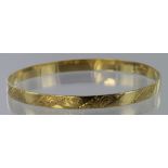 18ct yellow gold push on bangle with machine engraved design, weight 16.3g.