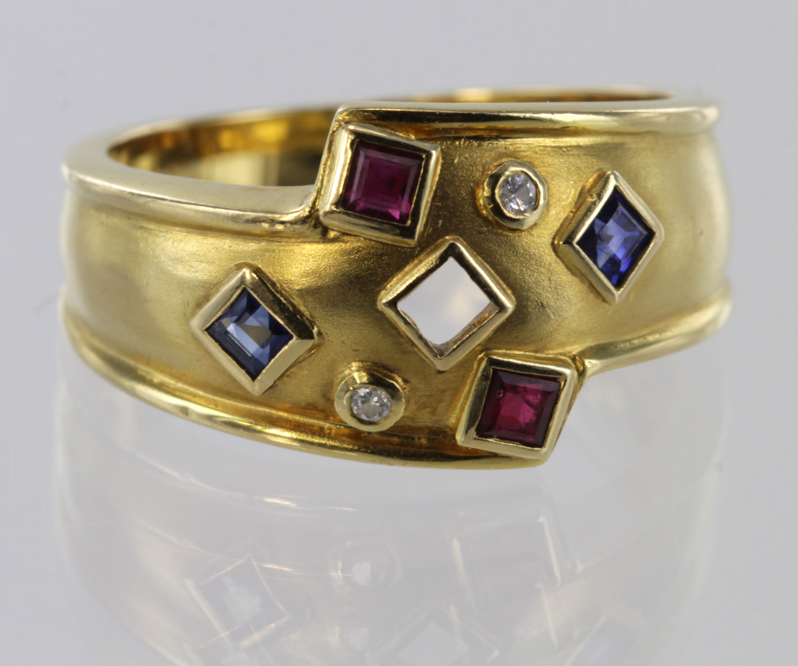 18ct yellow gold band ring set with sapphire, ruby and diamond, size M, weight 5.2g.