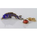 9ct coral snake charm, 9ct skull and crossbones charm, gilt articulated fish charm, weight 8g.