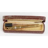 Yellow metal (tests as 9ct Gold) propelling fountain pen with 14ct Gold nib, contained in a