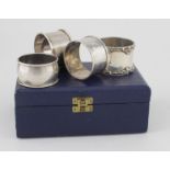 Four Silver napkin rings; various hallmarks, contained in an egg cup and spoon box. Weight of silver