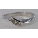 18ct white gold three stone princess cut diamond crossover design ring, size N, weight 3.2g.