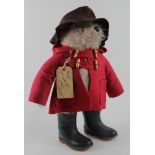 Paddington Bear by Gabrielle, red duffle coat, brown rain hat and black dunlop boots, with