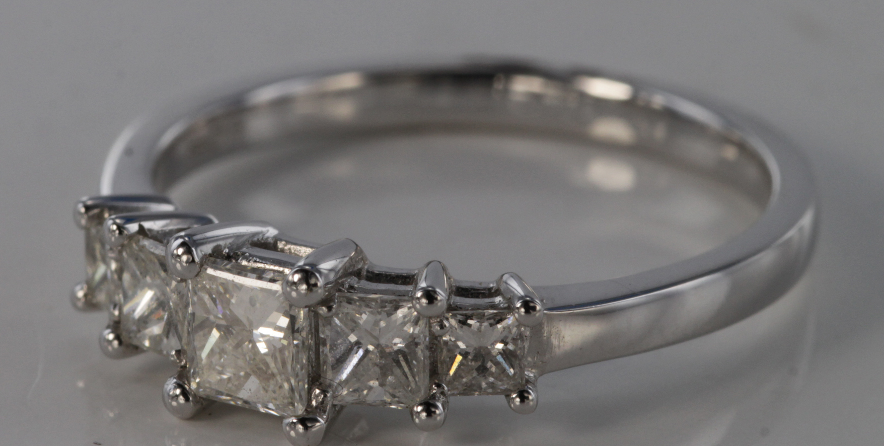 18ct white gold princess cut five stone ring, total diamond weight 0.82ct, size N, weight 2.6g.