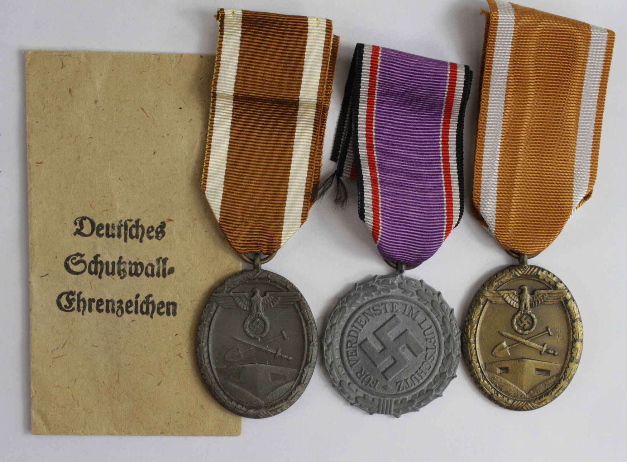 German WW2 West Walls Medals, one with packet of issue, plus a Luftshutz Medal (3)