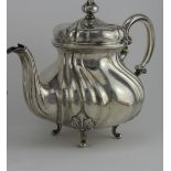 German silver teapot, lobed baluster form, scroll handle, domed cover on four bracket feet. Length
