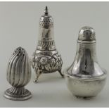 Three silver peppers, hallmarked for 1897, 1900 and 1940. The dumpier one (1940) has a Bakelite