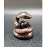 Japanese carved wood netsuke modelled as a coiled cobra with inset eyes, signed to the base.