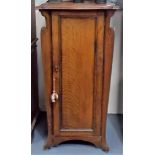 Edwardian oak Art Nouveau style music cabinet with shaped top over a hinged door enclosing four