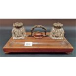 Walnut desk stand with two glass ink wells with brass hinge lids and with a brass carrying handle.