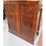 Mahogany floor standing cupboard with two doors enclosing three shelves and on a plinth base,