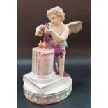 19th Century continental porcelain figure of a cherub watering flowers at a plinth, blue