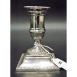 Edwardian silver weighted squat candlestick with beaded rims and acanthus stiff leaf embossed