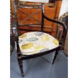 Regency ebonised and gilt painted elbow chair with cane seat and on ring turned supports.