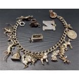 Silver charm bracelet with various silver charms including three loose silver charms, weight 2oz