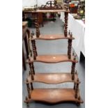 Walnut waterfall five tier wotnot, the serpentine shelves upon turned and barley twist supports,