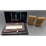 Two gold plated Dupont Paris lighters; together with a modern Yves Saint Laurent lighter within