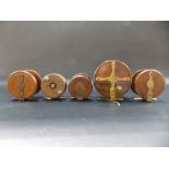 Five various turned wood brass mounted fly fishing reels.
