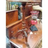 Mahogany tripod table with baluster turned and fluted pedestal over three foliate carved outswept