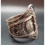 Chinese silver filigree buckle form bracelet, applied with scenes of buildings and figures amongst